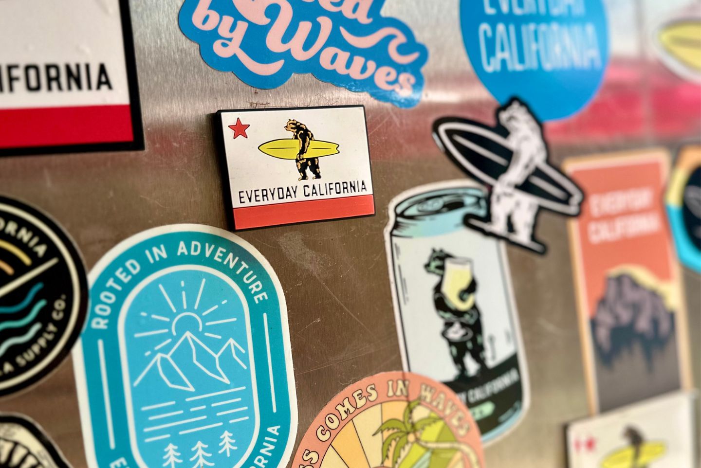 a everyday California flag magnet on the front of a fridge covered in Everyday California stickers 