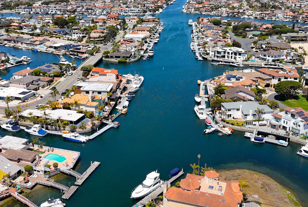 Aerial image of Huntington Harbour, featuring the calm scenic waters of the canals, yachts, and mansions.