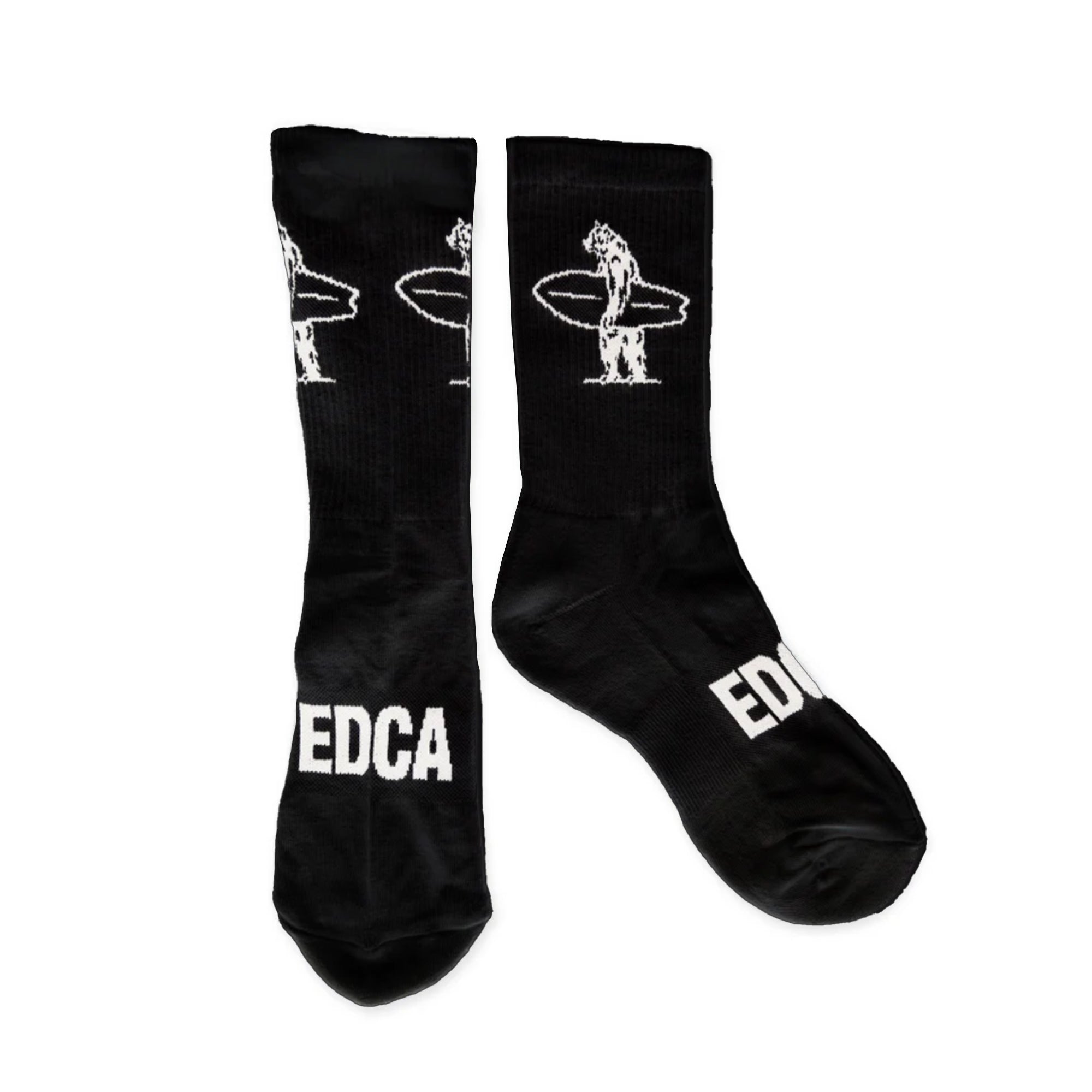 Black athletic socks with white logos on them that say "EDCA" across the top of the foot and a bear holding a surfboard on the inner and outer calf of the sock.