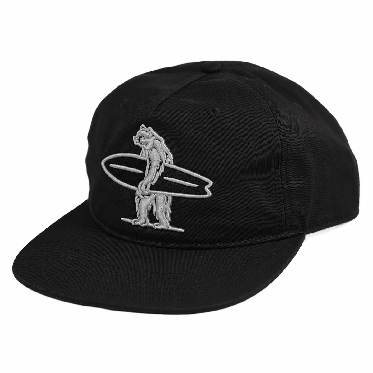 A black baseball cap with silver embroidered bear holding a surfboard on the front of the hat.