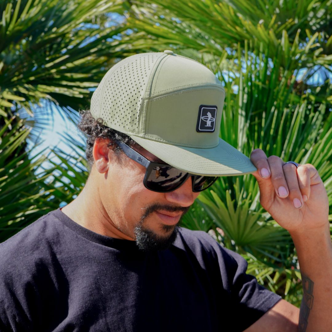 The sage cormorant hat in the sunshine on front of some palm trees in California 