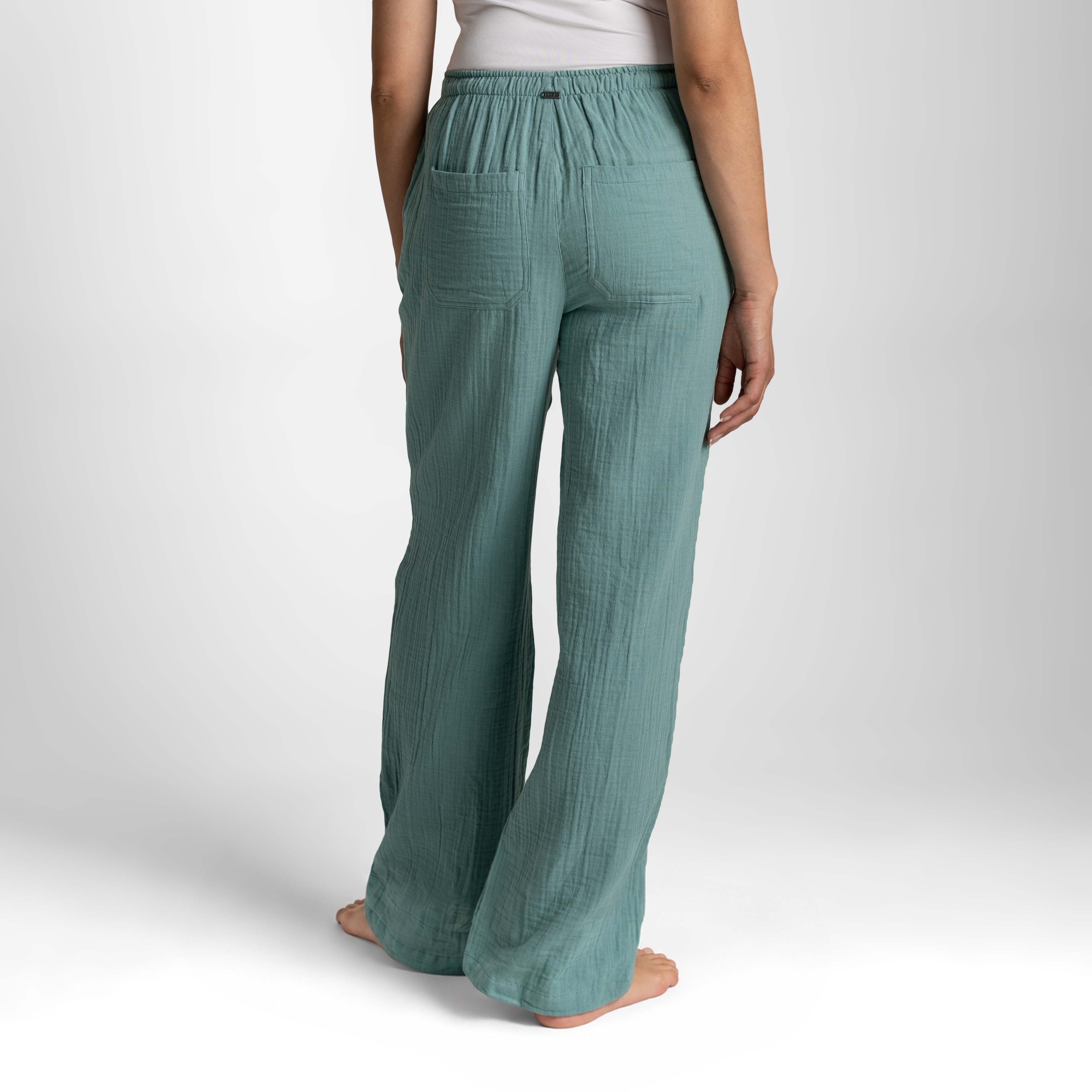 Teal wide-leg pants worn by a person on a white background
