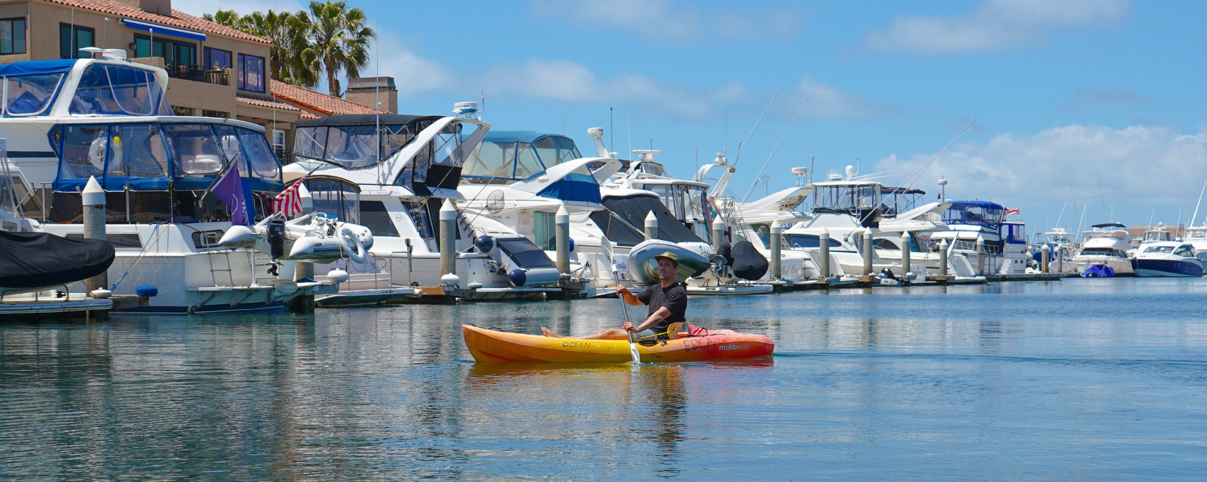 Kayak rental paddling through Huntington Harbour near Huntington Beach, California. The calm waters of Huntington Harbour make it perfect for kayaking and stand up paddle boarding.