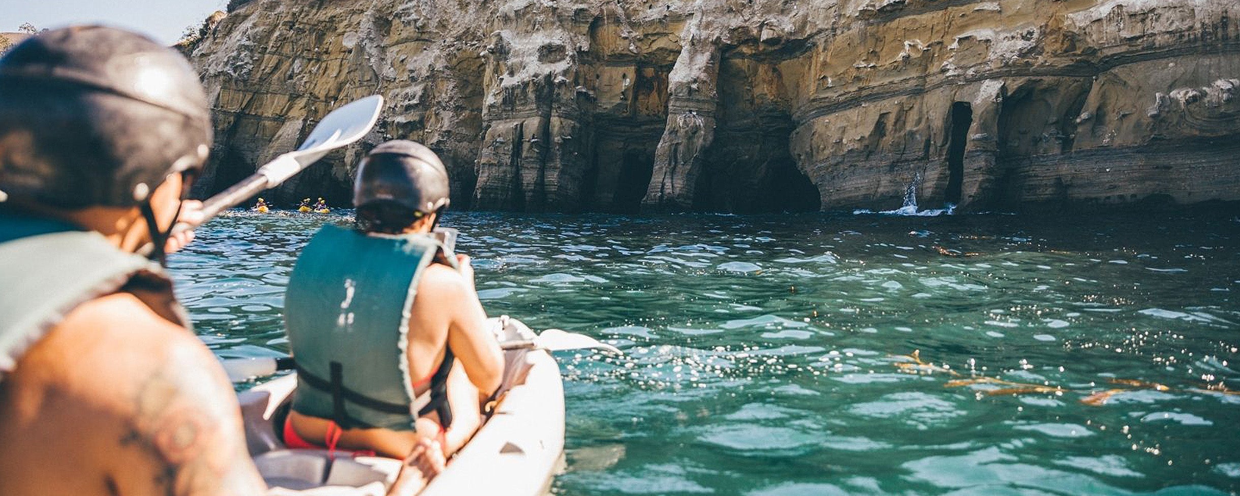 Two kayakers kayaking in San Diego on a Kayak Rental with Everyday California in front of the sea caves in La Jolla Ecological Reserve 
