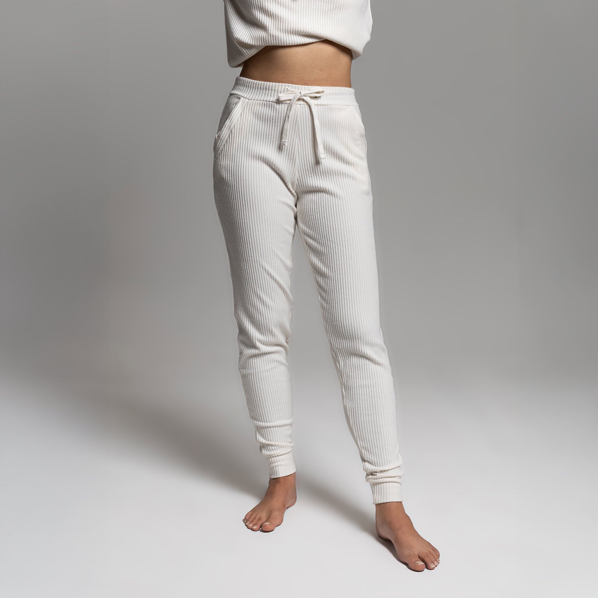 Female model wearing white ribbed joggers