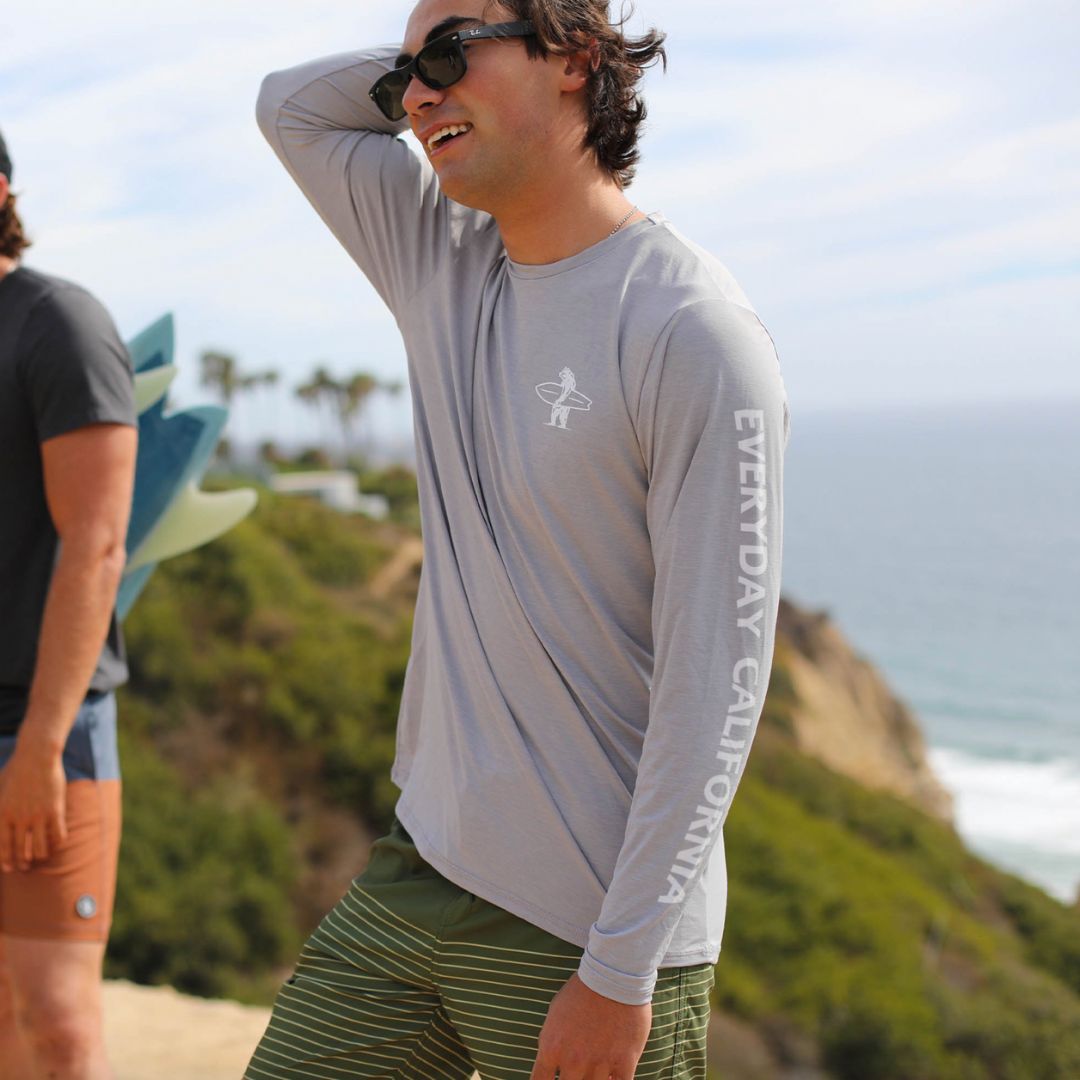 A California man earring a light grey rash guard on the cliffside enjoy the sun