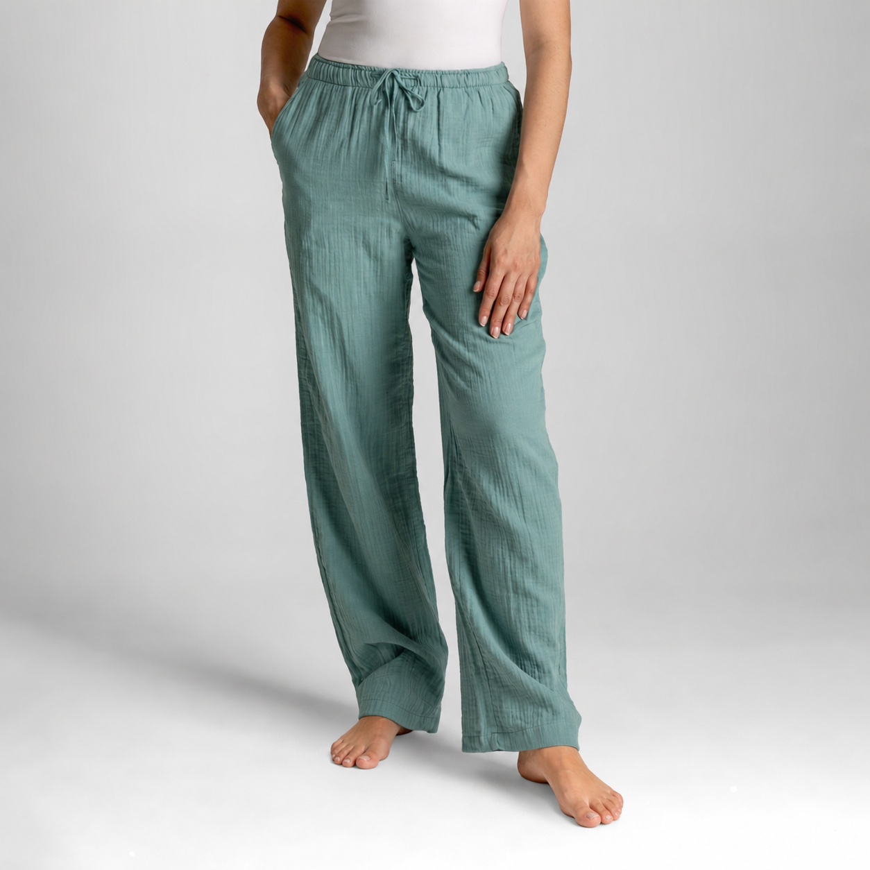 Teal pants worn by a person on a plain background