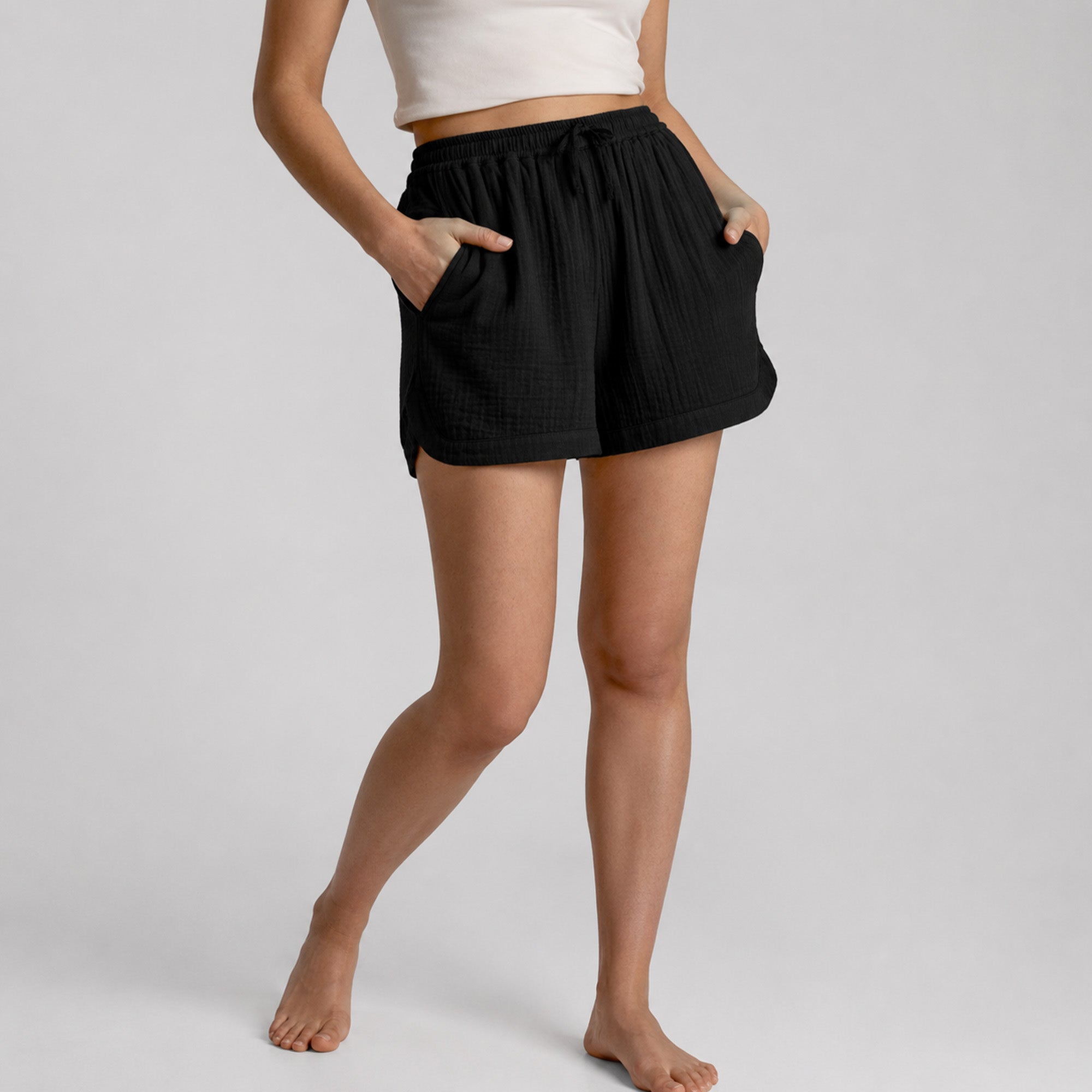 Person wearing black shorts on a plain background
