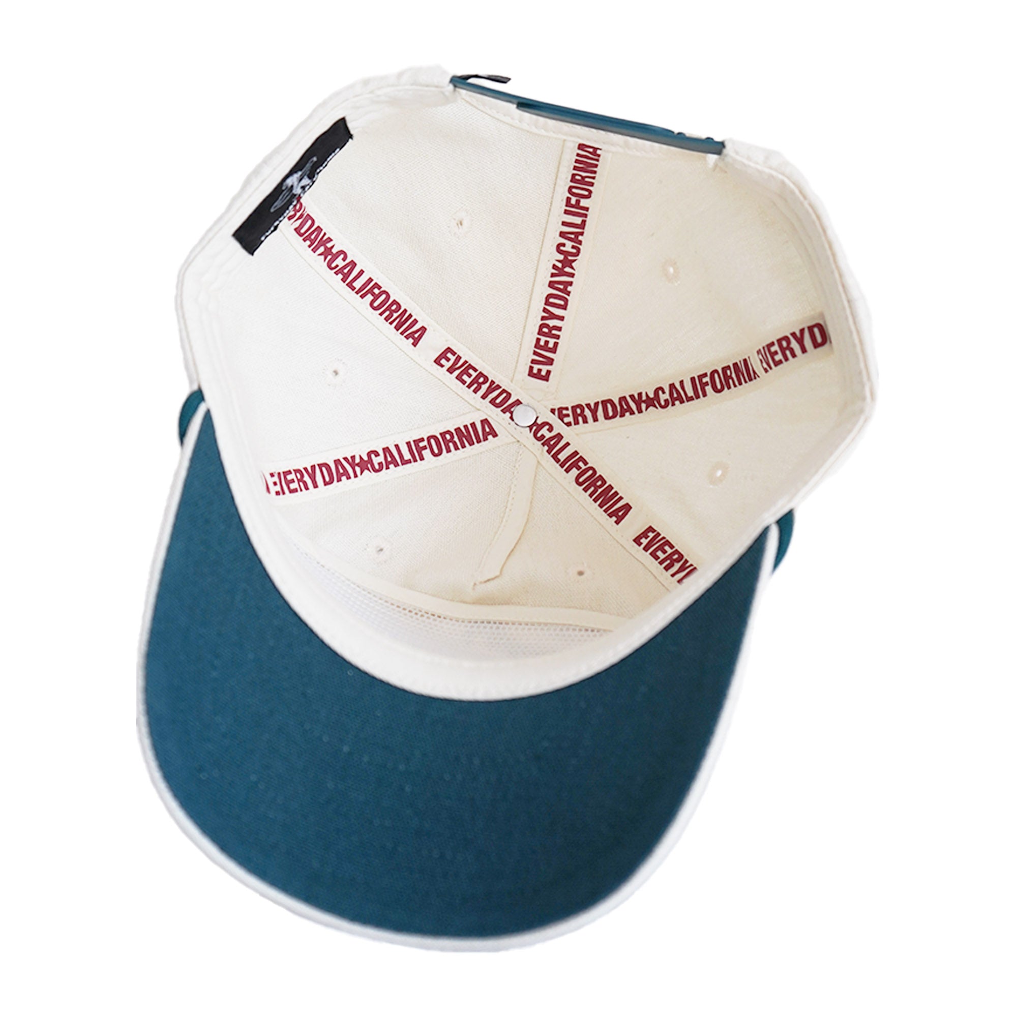 Interior of cream snapback showing teal brim and "Everyday California" branded tape