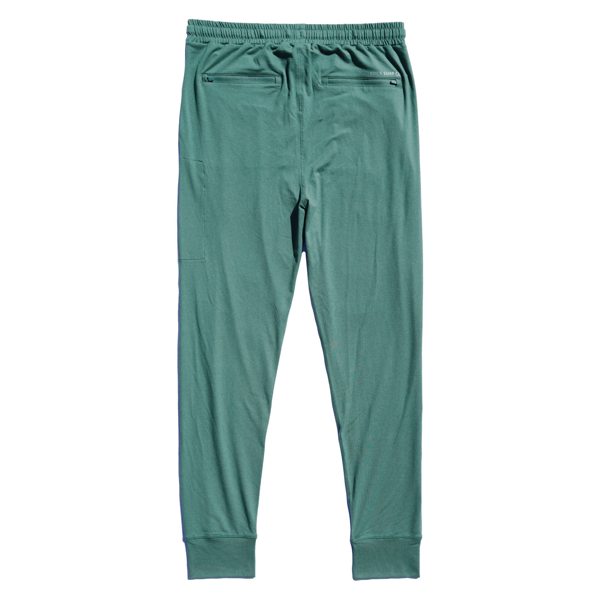 Green Bayside Performance joggers backside image, featuring a small reflective vinyl logo that says 'EDCA SURF CO.' above the back zip pocket.