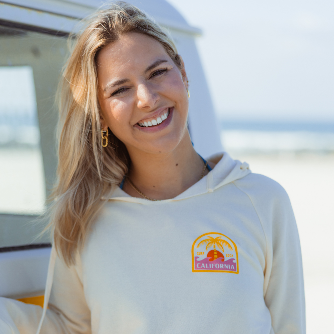 The California Sunshine Club Hoodie on Kate in Coronado next to a yellow VW bus