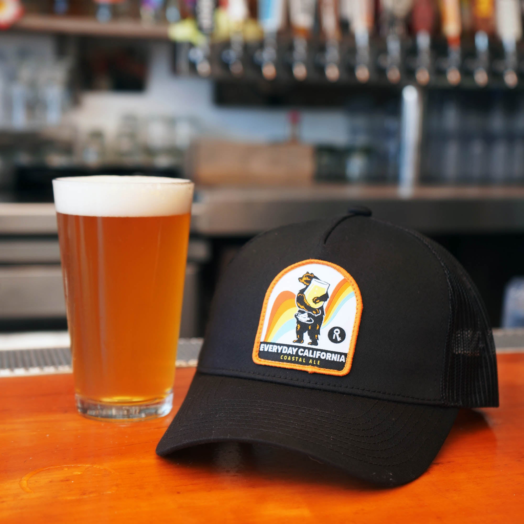 Everyday California Costal Ale Snapback pictured next to a glass of beer