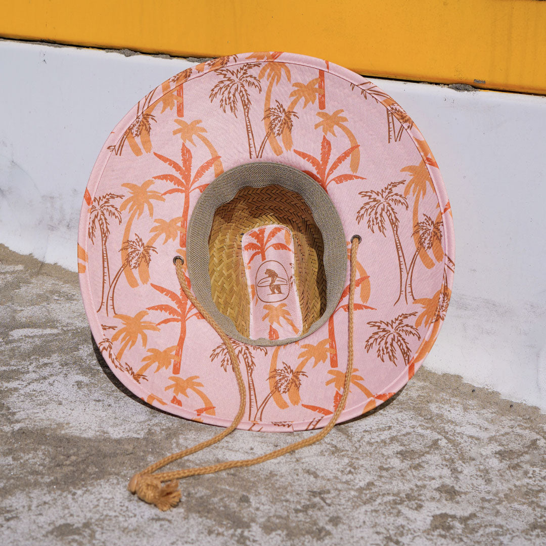 A beige Eddie Straw Hat with a wide brim and a logo patch on the crown, featuring a natural straw weave and an adjustable chin strap.