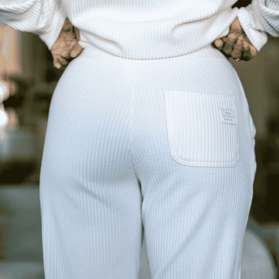 Closeup image of the backside of the Malibu Ribbed Joggers, showing the detail of the ribbed cotton fabric and the back pocket featuring a minimal woven label that says 'EDCA SURF CO.' on it.