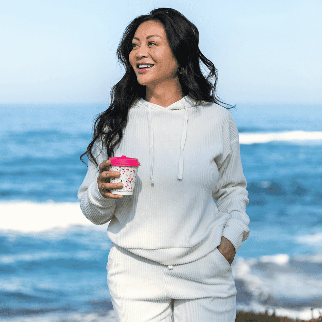 Malibu hoodie and jogger set in the color off-white, featuring 4x4 ribbed cotton fabric worn on a size small model at the beach.