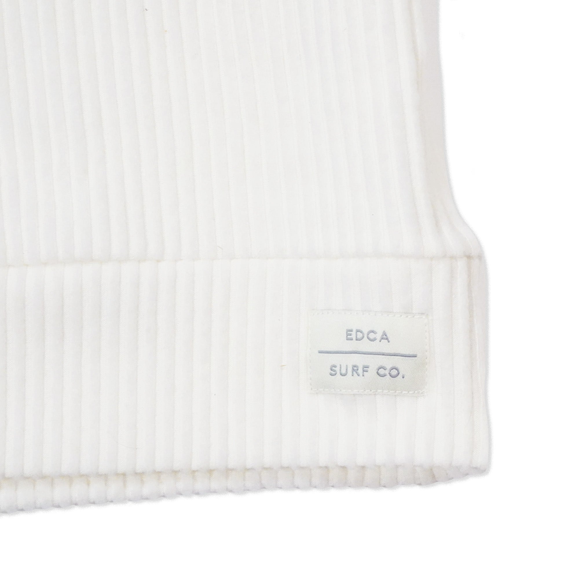 Zoomed in bottom right corner of White Everyday California ribbed women's hoodie. Stitched patch reads "EDCA Surf Co."