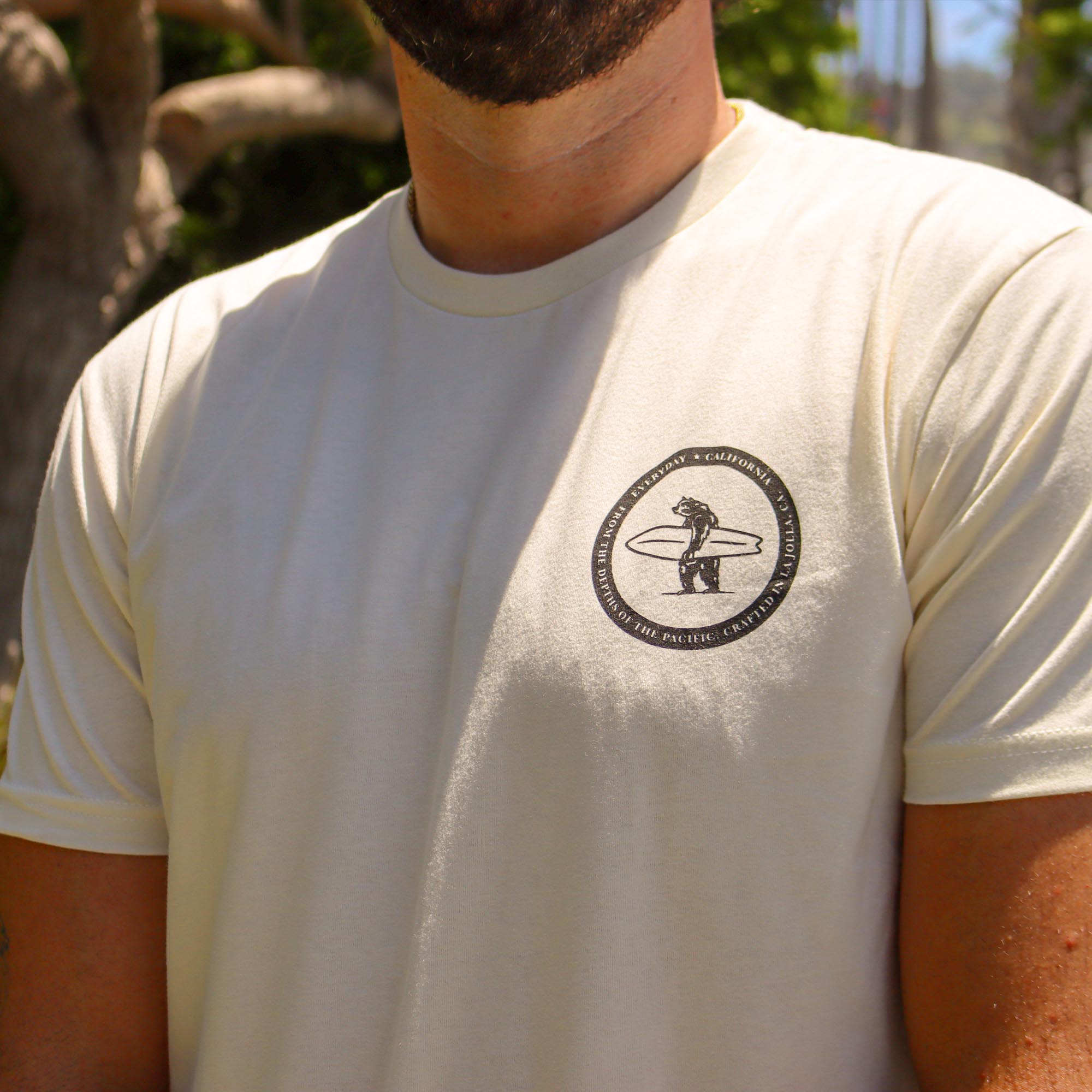 A model showcasing the men's Salty tee which showcases Brutus in the top left corner