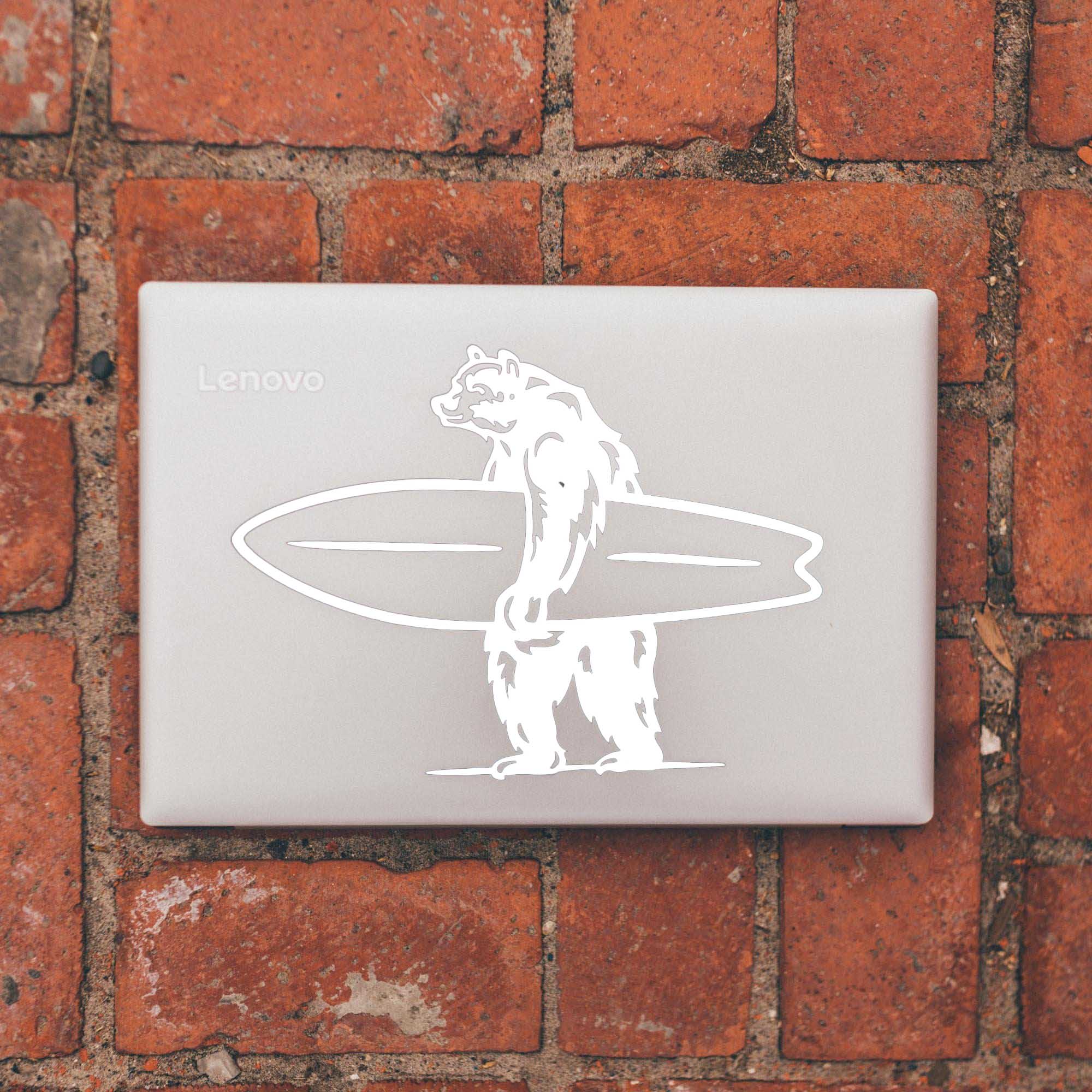 Large white laptop decal sticker of a bear holding a surfboard.