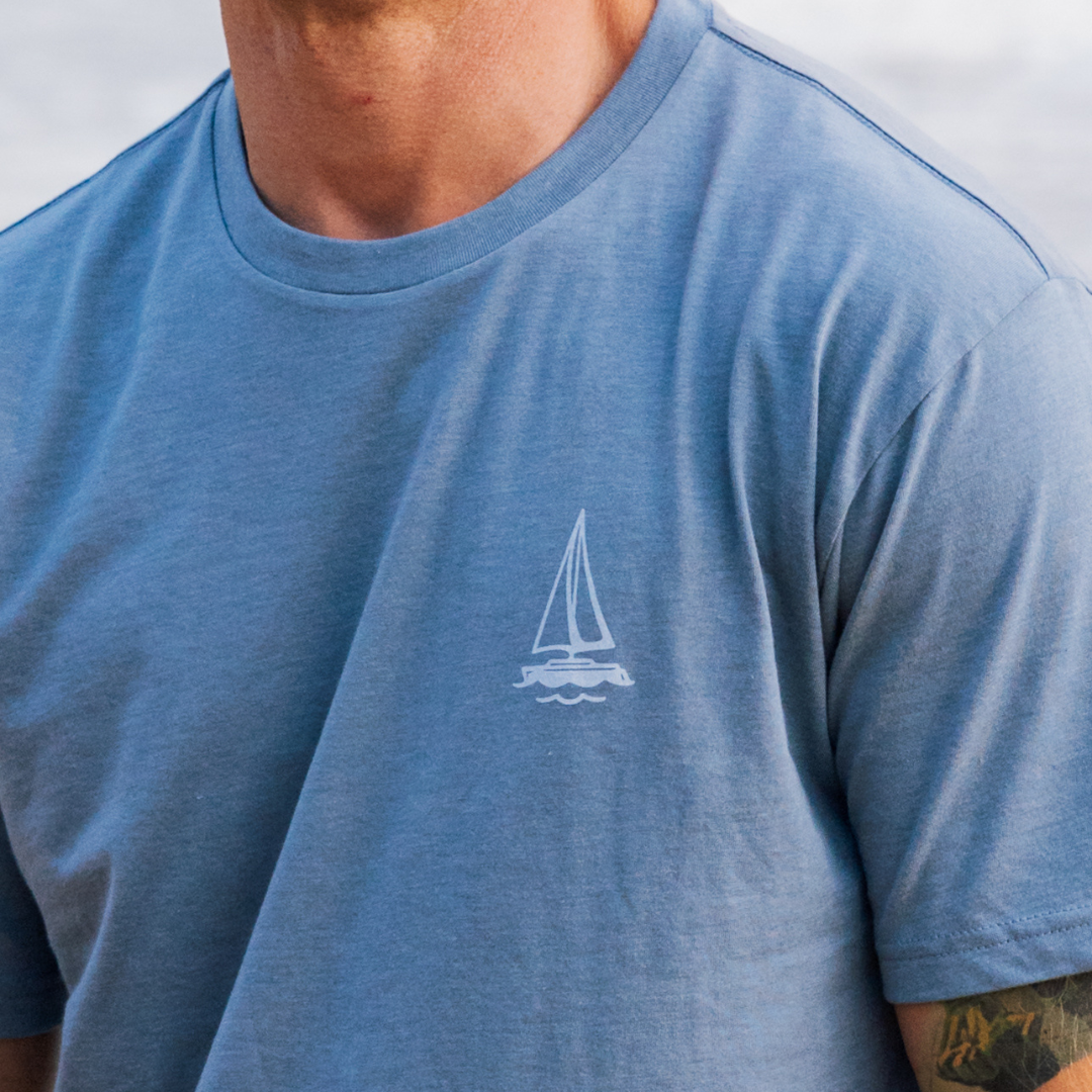 Blue t-shirt with a sailboat logo worn by a person