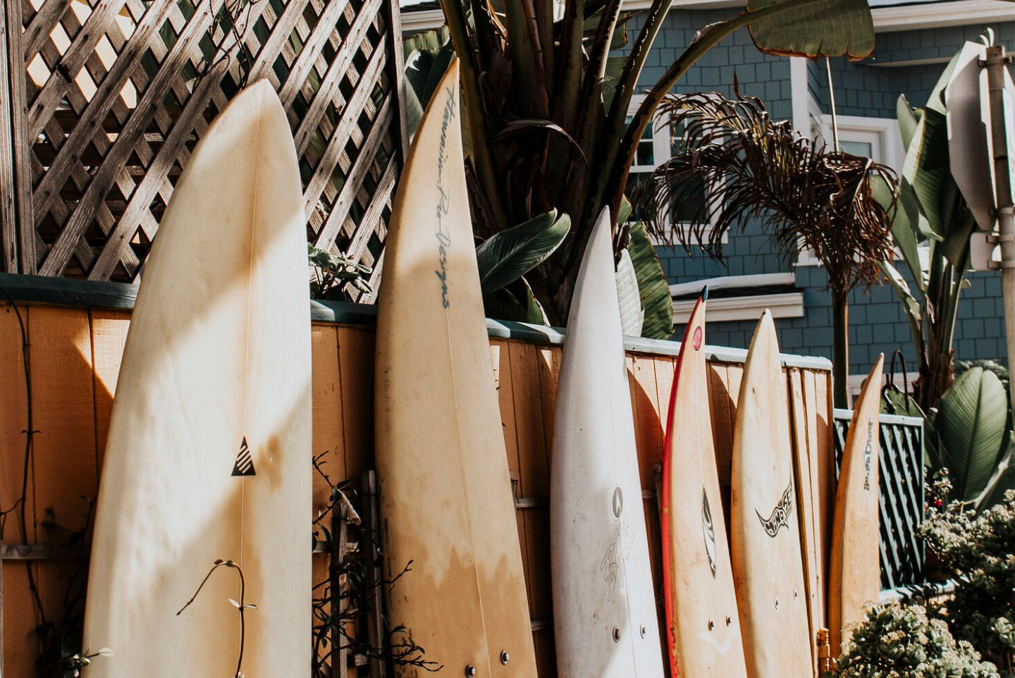 Surfboards lined up along the fence of a house in Pacific Beach San Diego 