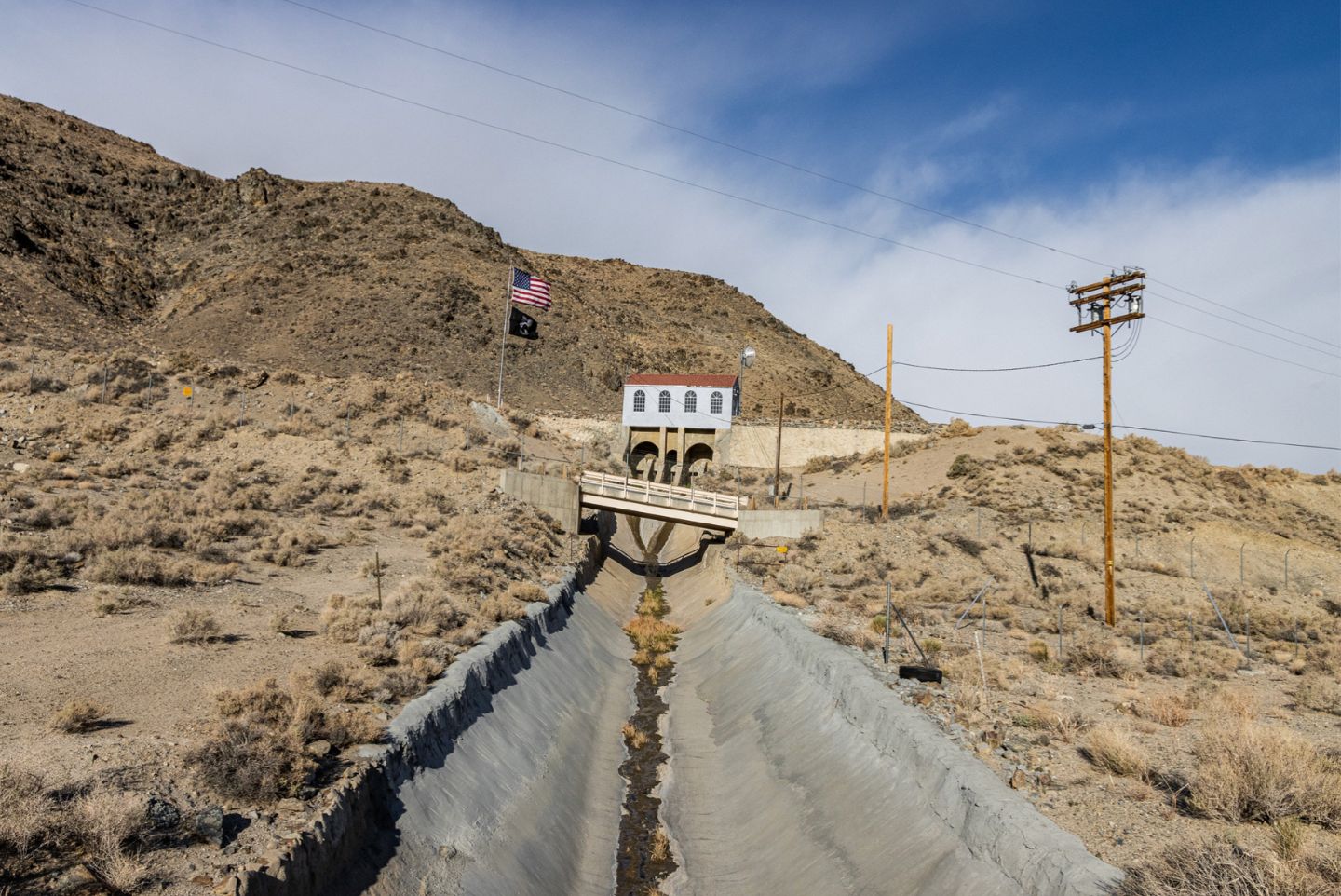 A very dry storm drain with no water and a very dry and sandy desert