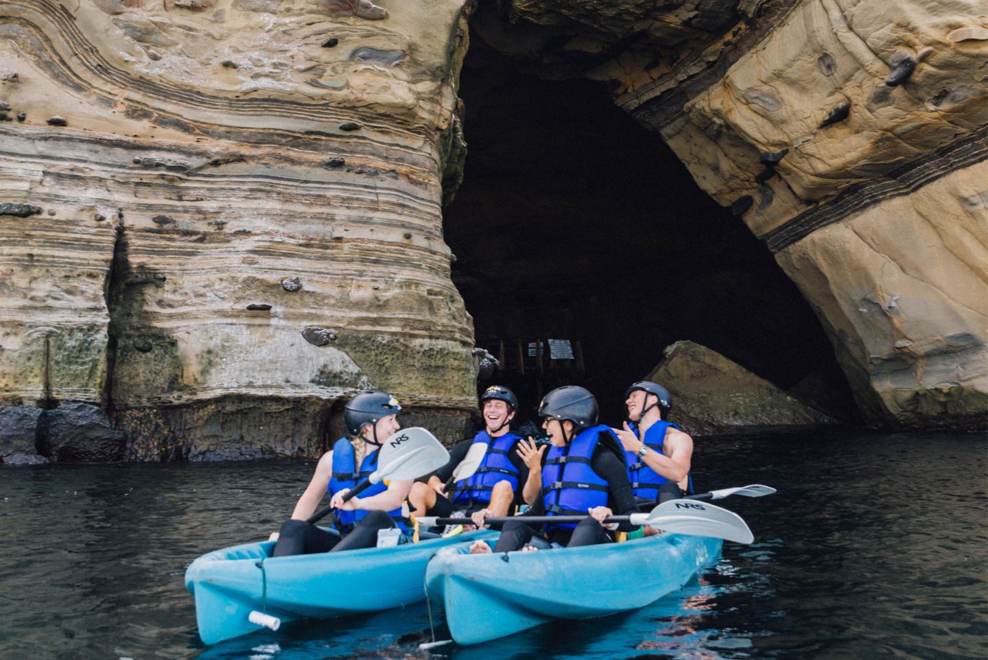 A group of 4 kayakers in san Diego on a kayaking tour of the sea caves in San Diego with everyday California 