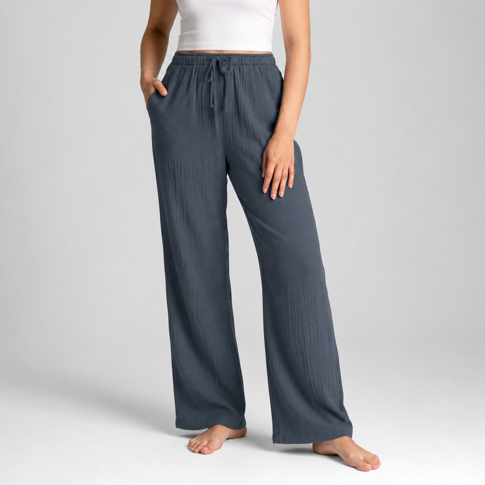 Person wearing dark gray wide-leg pants on a light gray background