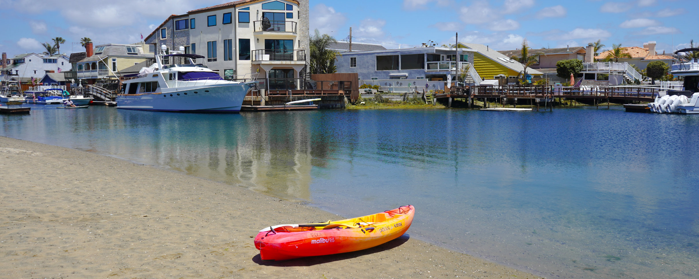 Kayak rental sitting on the shore of Huntington Habour in Huntington Beach, California. The calm waters of the Huntington Harbour make it perfect for kayaking and stand up paddle boarding. 