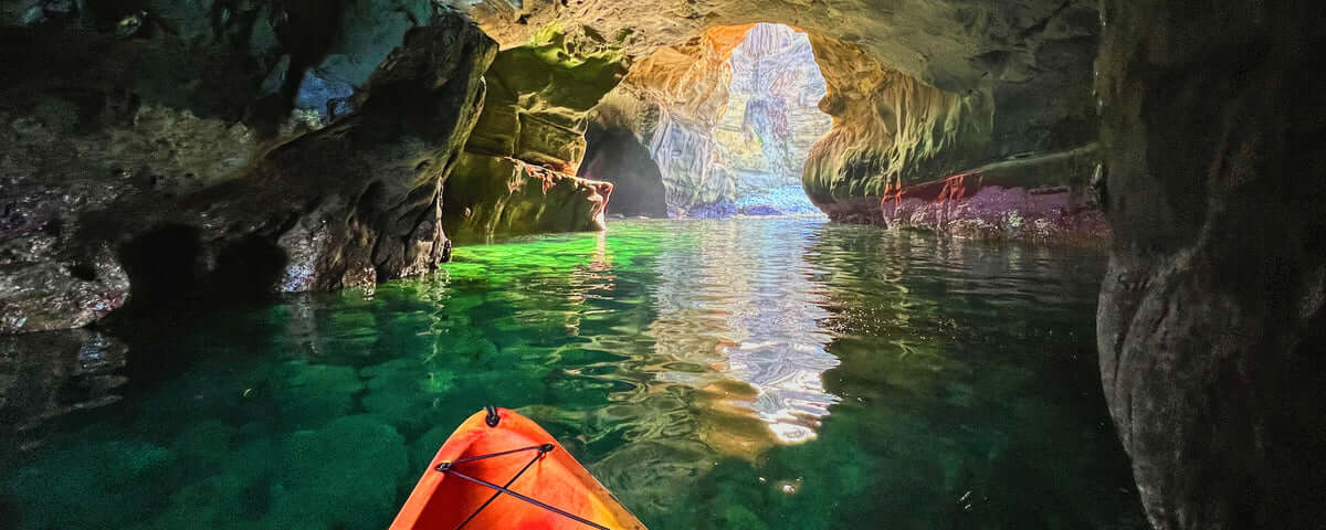 The nose of a kayak inside of one of the sea caves in La Jolla. The kayaker is on a tour of the Seven Sea Caves in La Jolla with Everyday California.