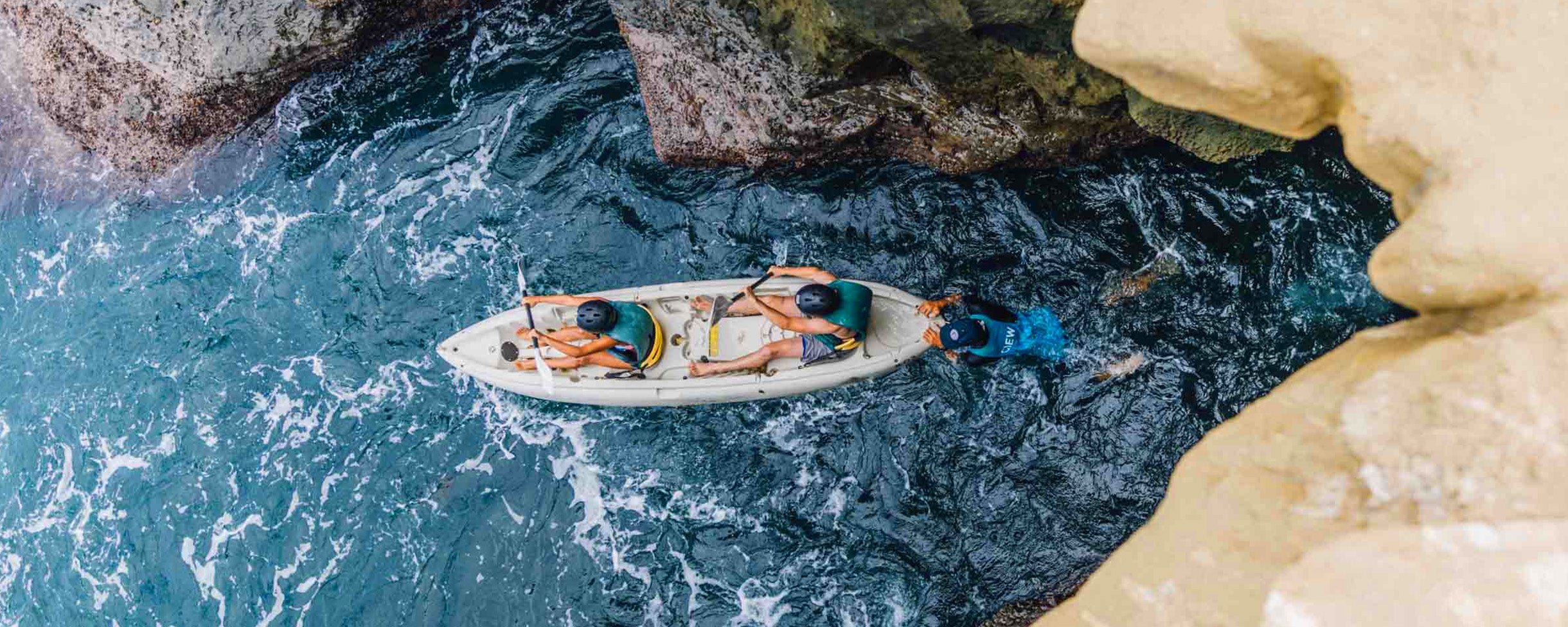 Two kayakers on a Sea Cave Kayak Tour being led out of a Sea Cave by their tour guide from Everyday California from above.