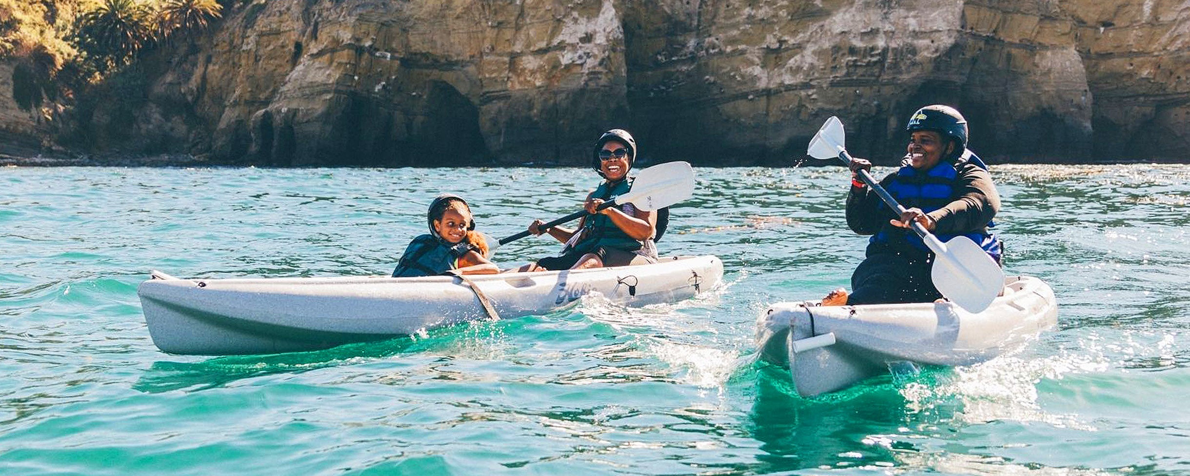 A family kayaking by the Seven Sea Caves with Everyday California Kayak Rentals at the La Jolla Ecological Reserve.