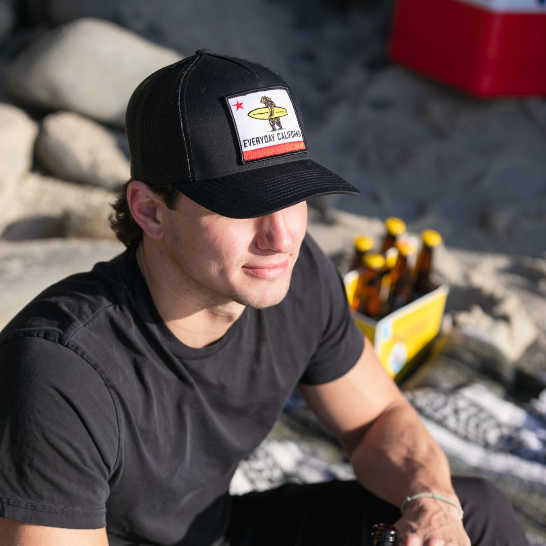 Man enjoying the beach in his Shores Hat in Black from Everyday California 