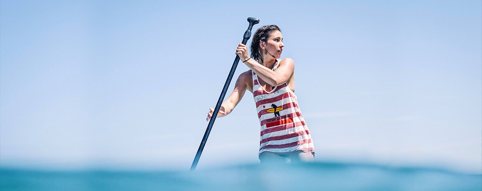 SUP- Stand Up Paddle-board Lessons in San Diego with Everyday California. Sunny day, a girl on her paddle board looking away for her instructor on her SUP Lesson. 