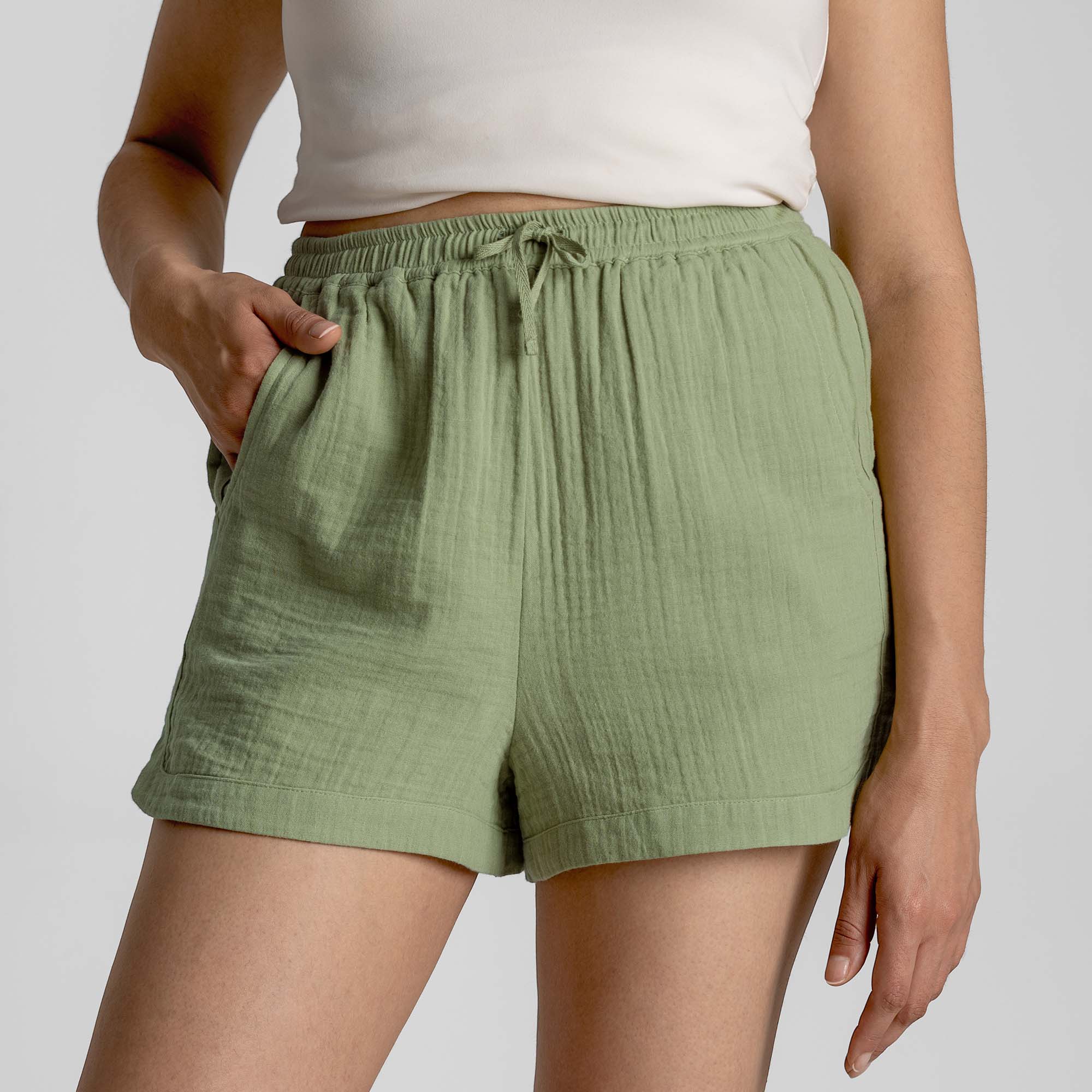 Person wearing green shorts on a plain background