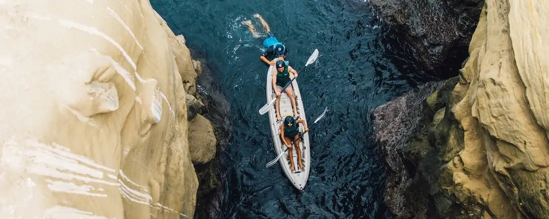 Two people kayaking in and out of the San Diego Sea Caves in La Jolla San Diego on a Sea Cave Kayak Tour