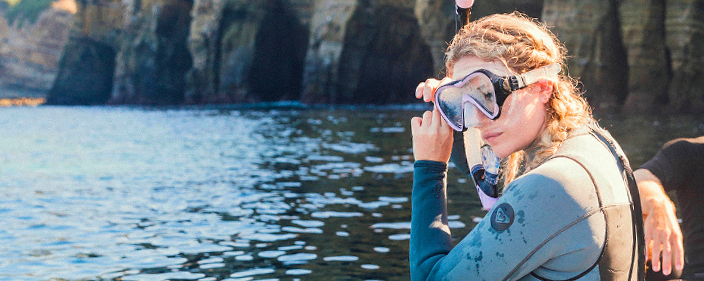 Snorkeler on a snorkeling tour with Everyday California about to jump into the water in front of the Sea Caves in San Diego.