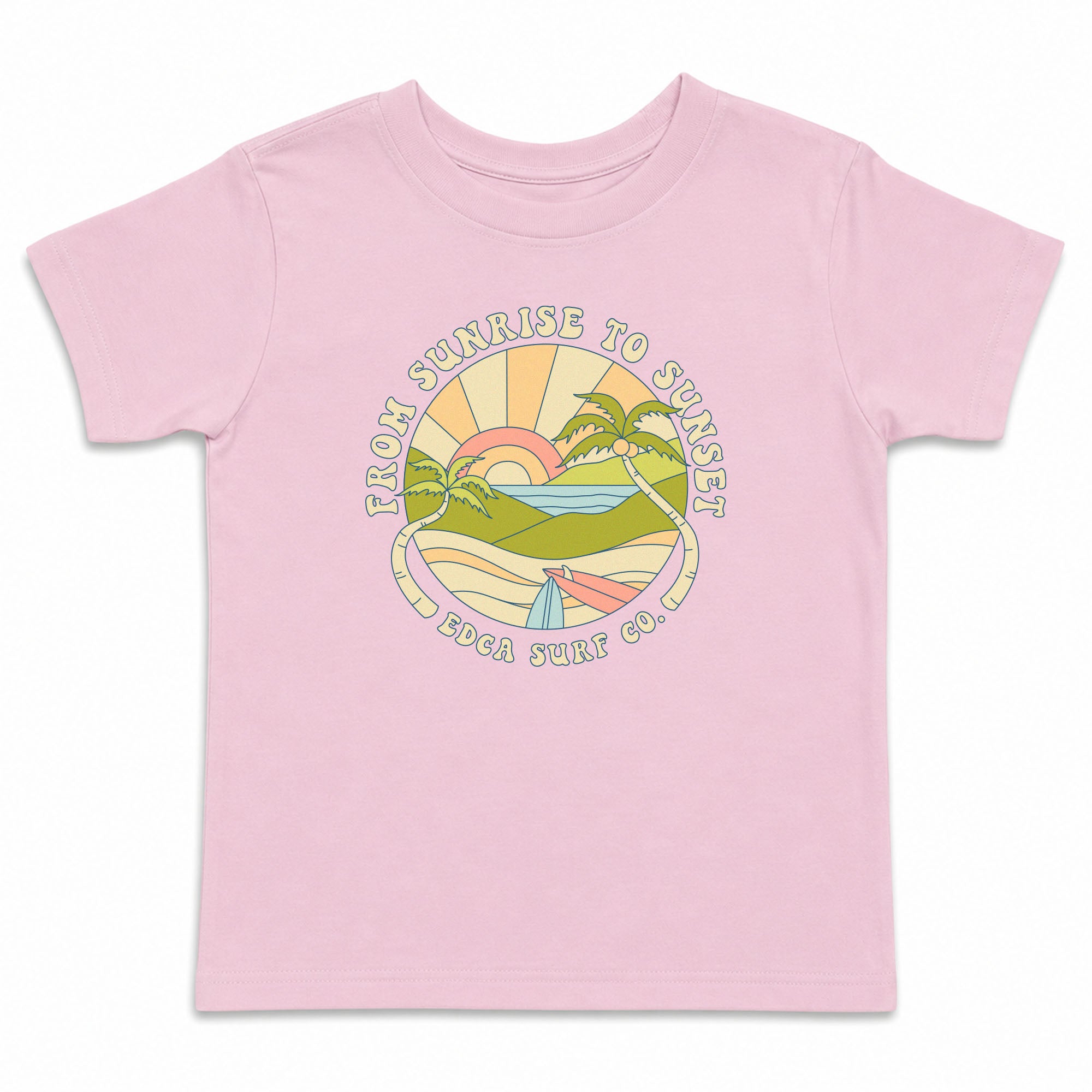 Pink kids t-shirt with a screenprinted front chest graphic that says "FROM SUNRISE TO SUNSET" on top of an image of ocean waves and surfboards, and "EDCA SURF CO." below the image.