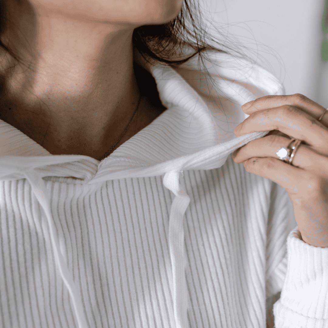 Closeup lifestyle image of the Malibu Ribbed Hoodie, showing the detail of the ribbed cotton fabric around the neckline. 