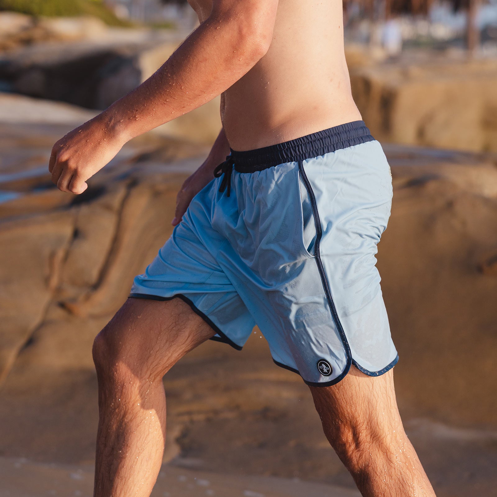 Man wearing Everyday California light blue board shorts with navy trim 