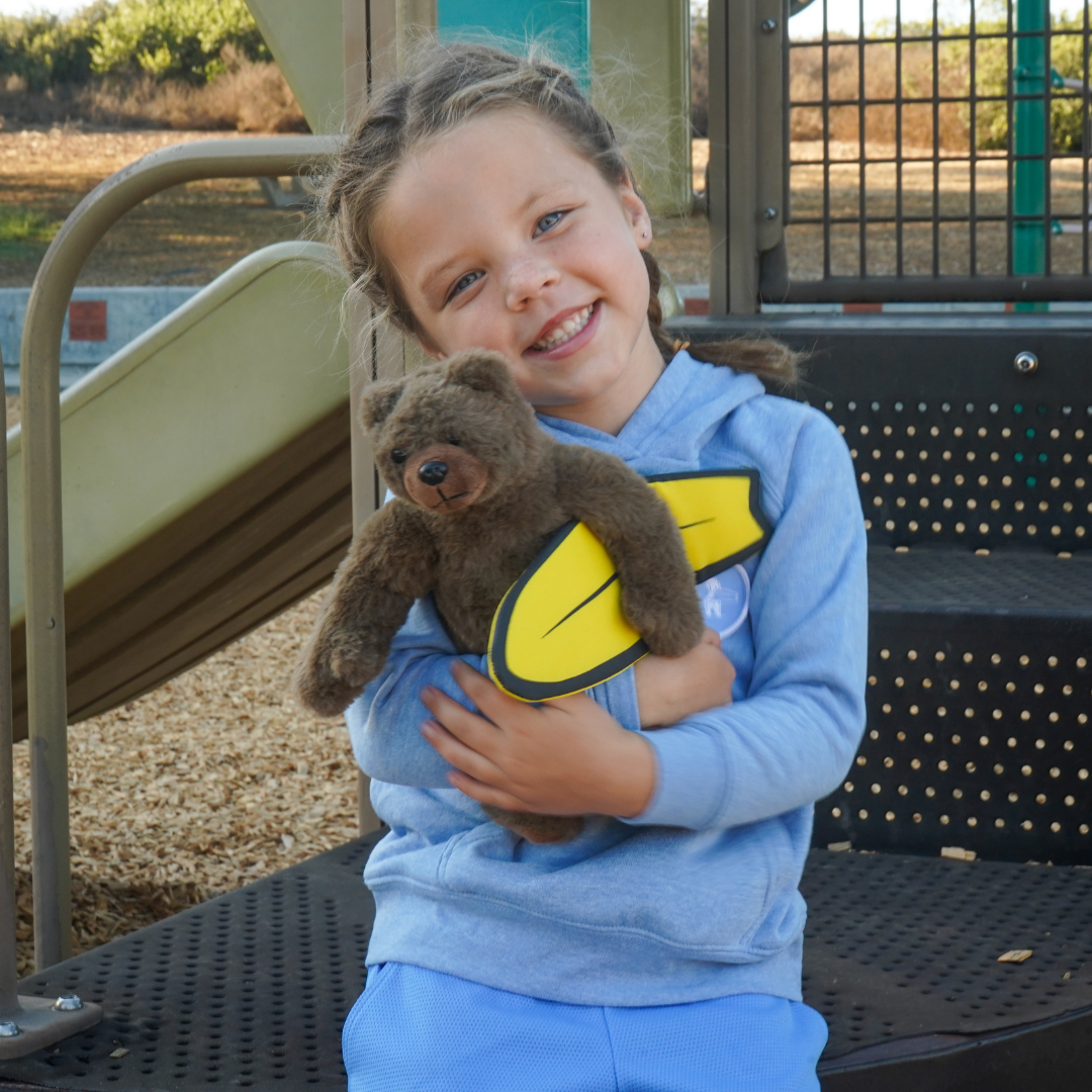Little girl with Brutus Plush toy made from recycled water bottles.