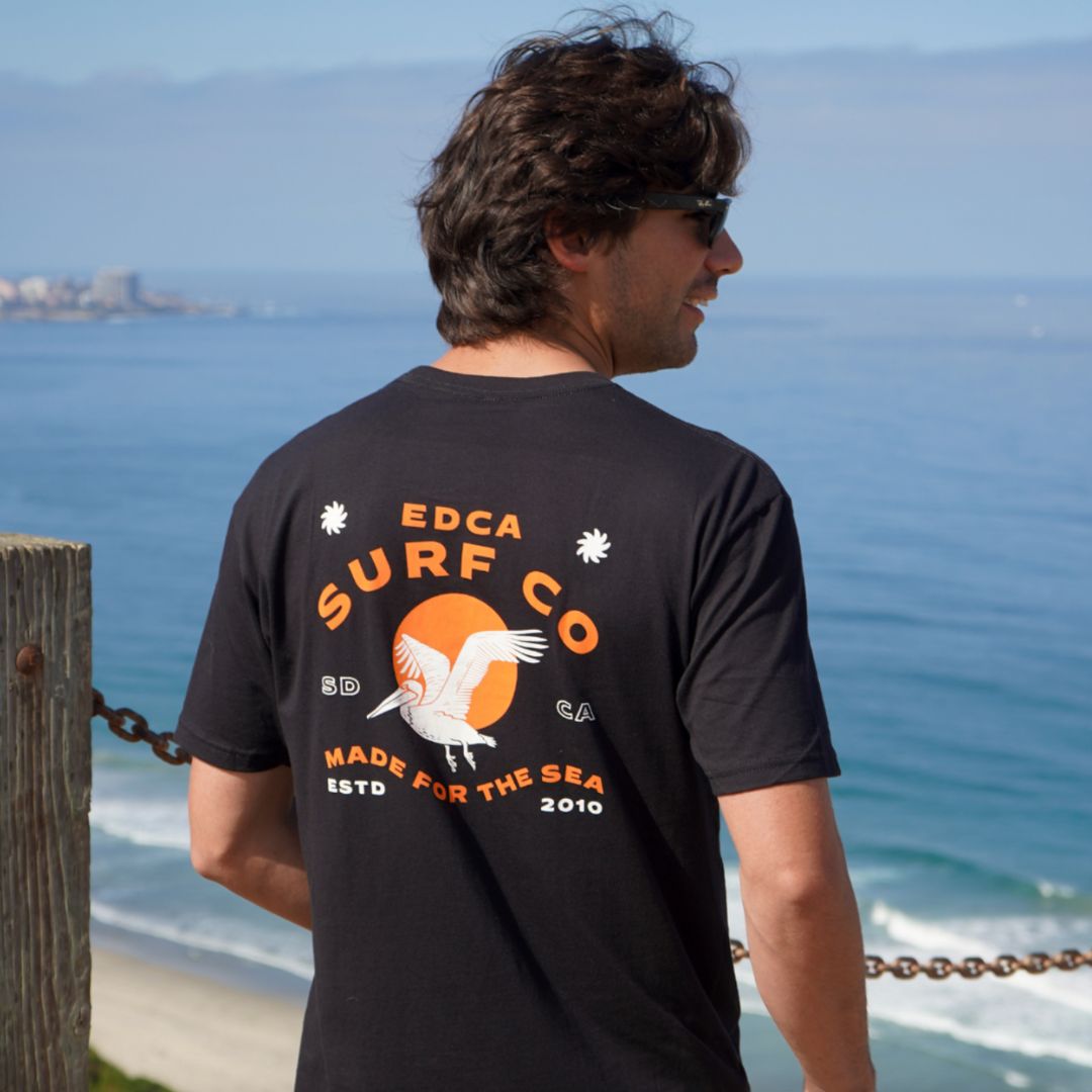 California guy wearing the waterbird tee in front of the ocean and cliffside 
