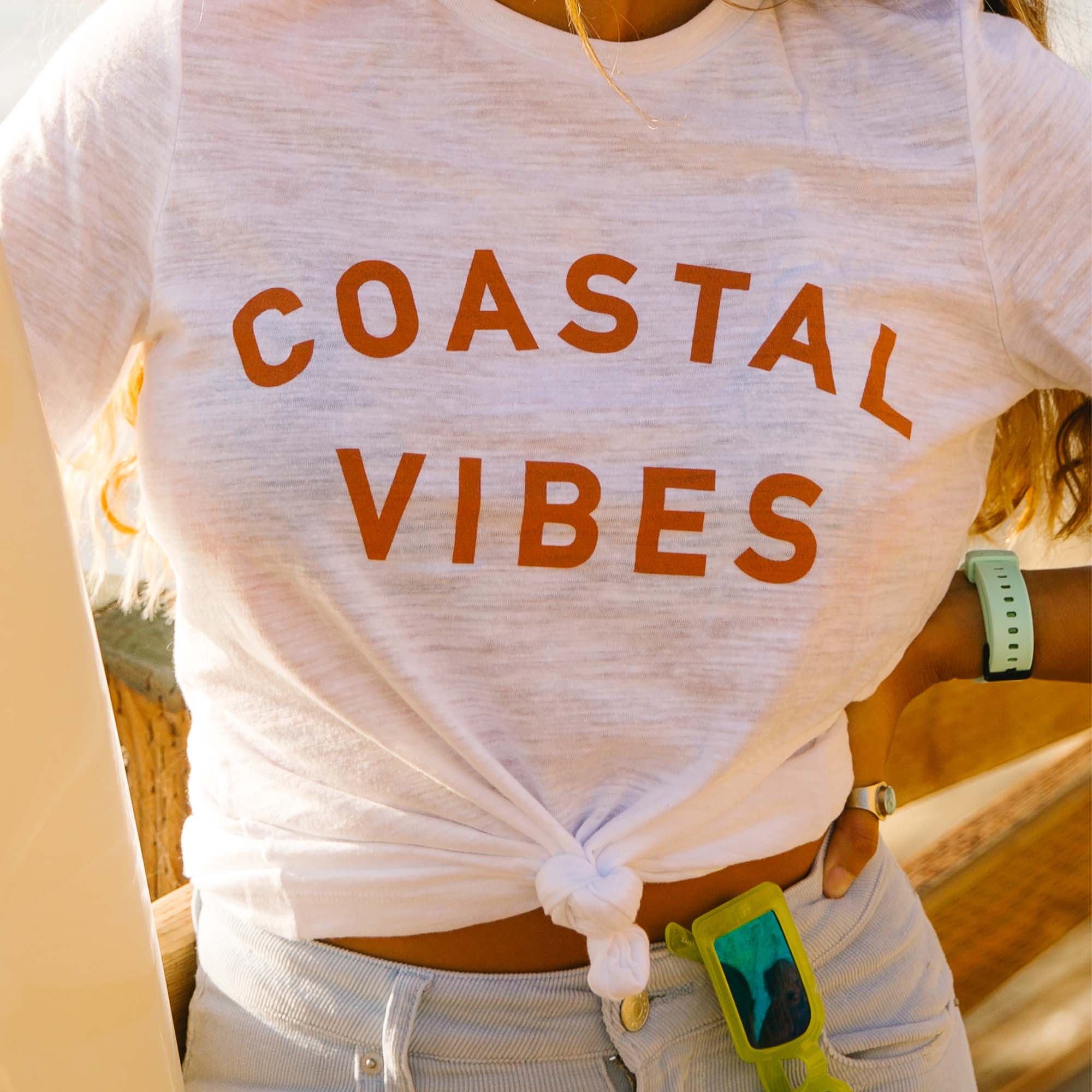 Coastal Vibes tee on girl standing by the beach in California